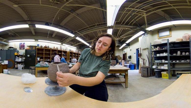 Panoramic view of student sculpting in an art studio